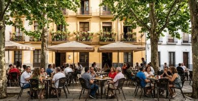 Plaza del Campo del Príncipe en el Realejo con terrazas de cañas bajo los plátanos de sombra y balcones con geranios