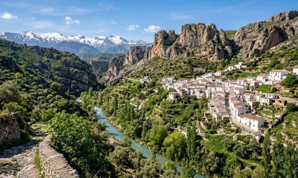 Pueblo blanco de Dudar en el canon del rio Aguas Blancas con Sierra Nevada al fondo sendero del Canal de los Franceses